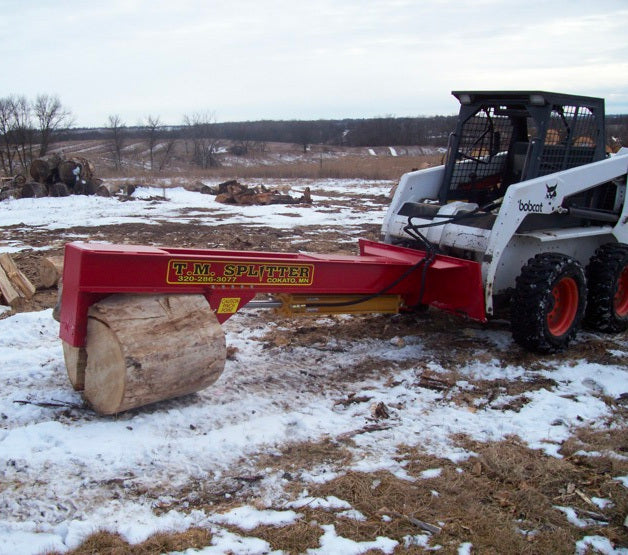 A single wedge TM Manufacturing Pro Series log splitter splitting a large round