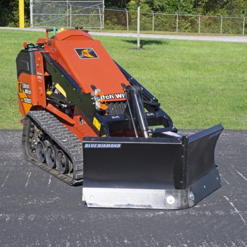 blue diamond v-blade attachment for mini skid steer ready to action in the field